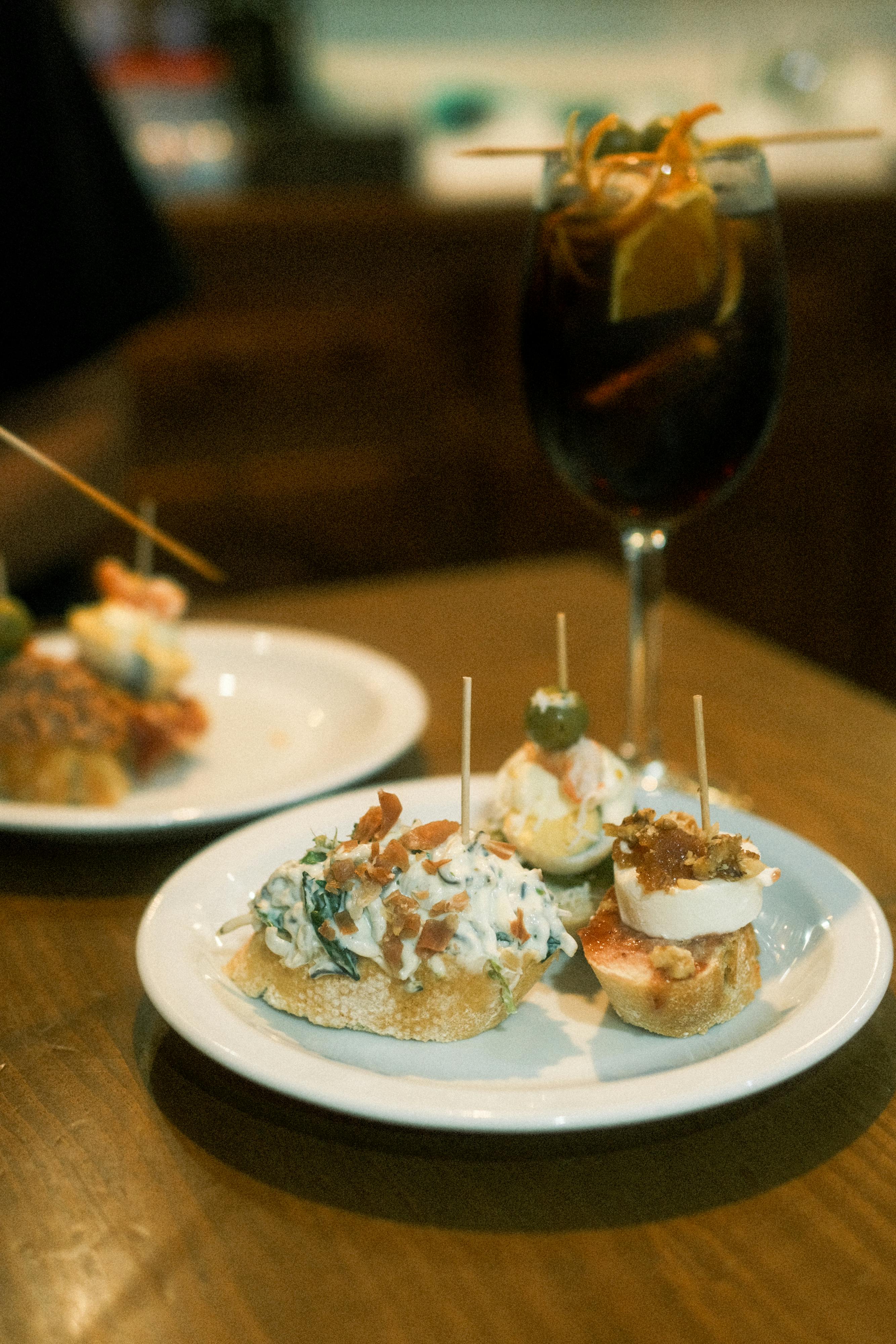 Small tapas-style plates and wine on a bar counter, used to evoke the informal rhythm of eating in Murcia.